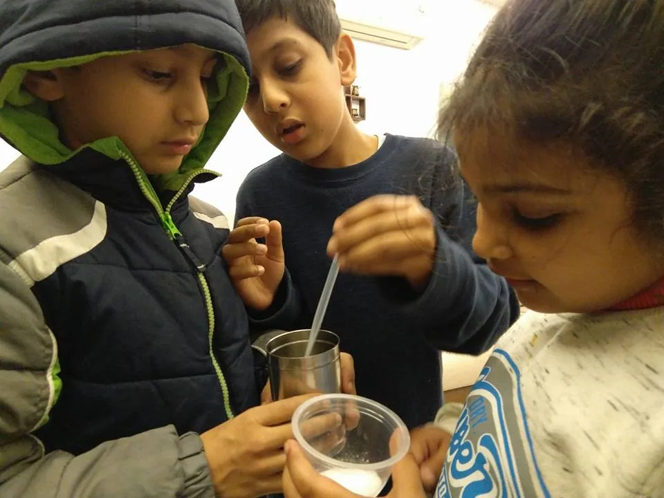 Three young scientists, thrilled to have made carbon dioxide from citric acid and baking soda.

(This is the before-the-