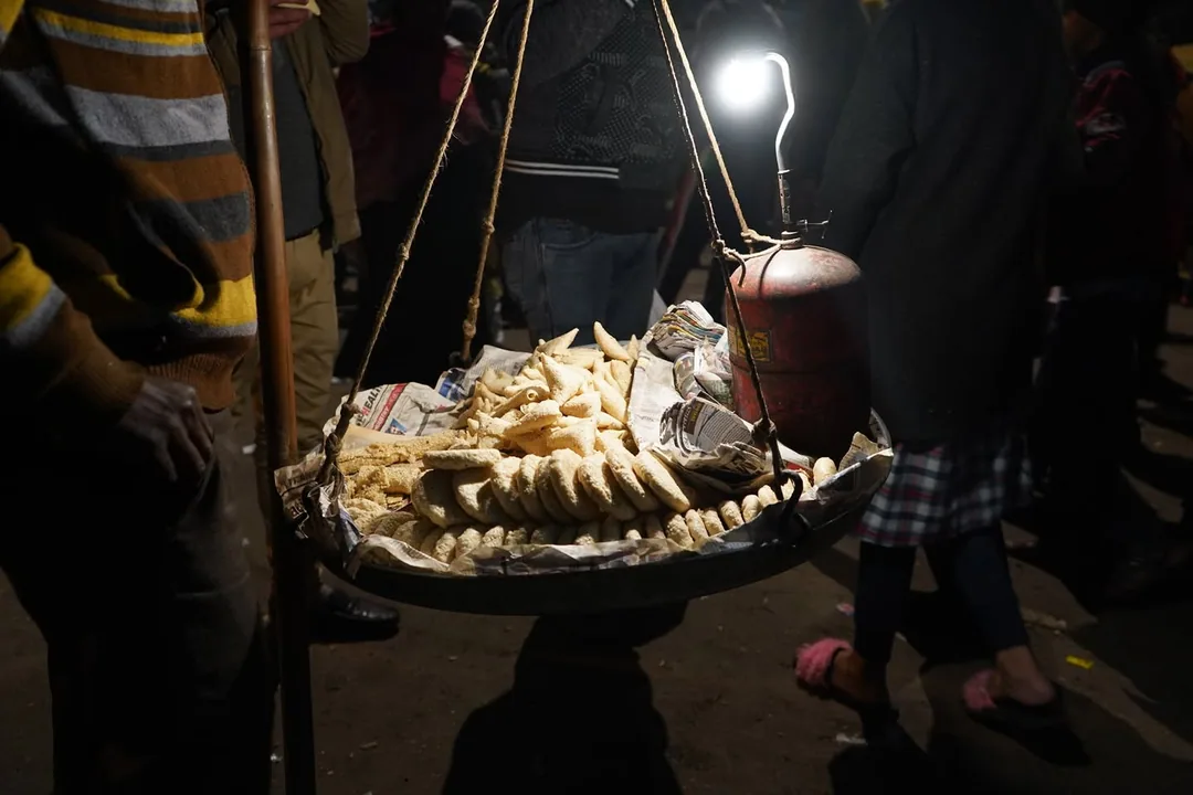 The street vendors, selling their wares under the massive street over bridge. The crowd of idle onlookers like me brings