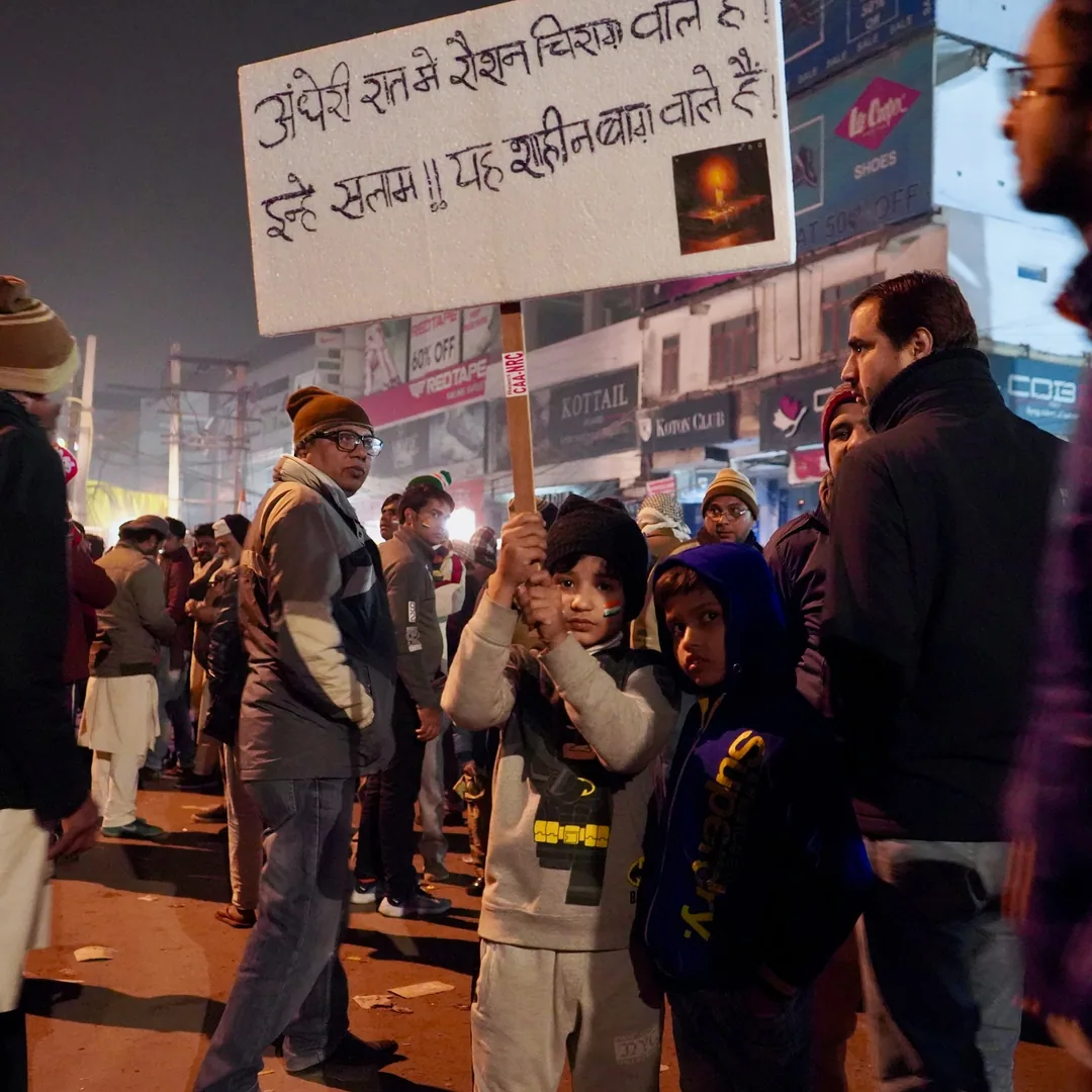 Do these cute kids understand the message on their board?

I suppose the detention center, an art Installation and popul